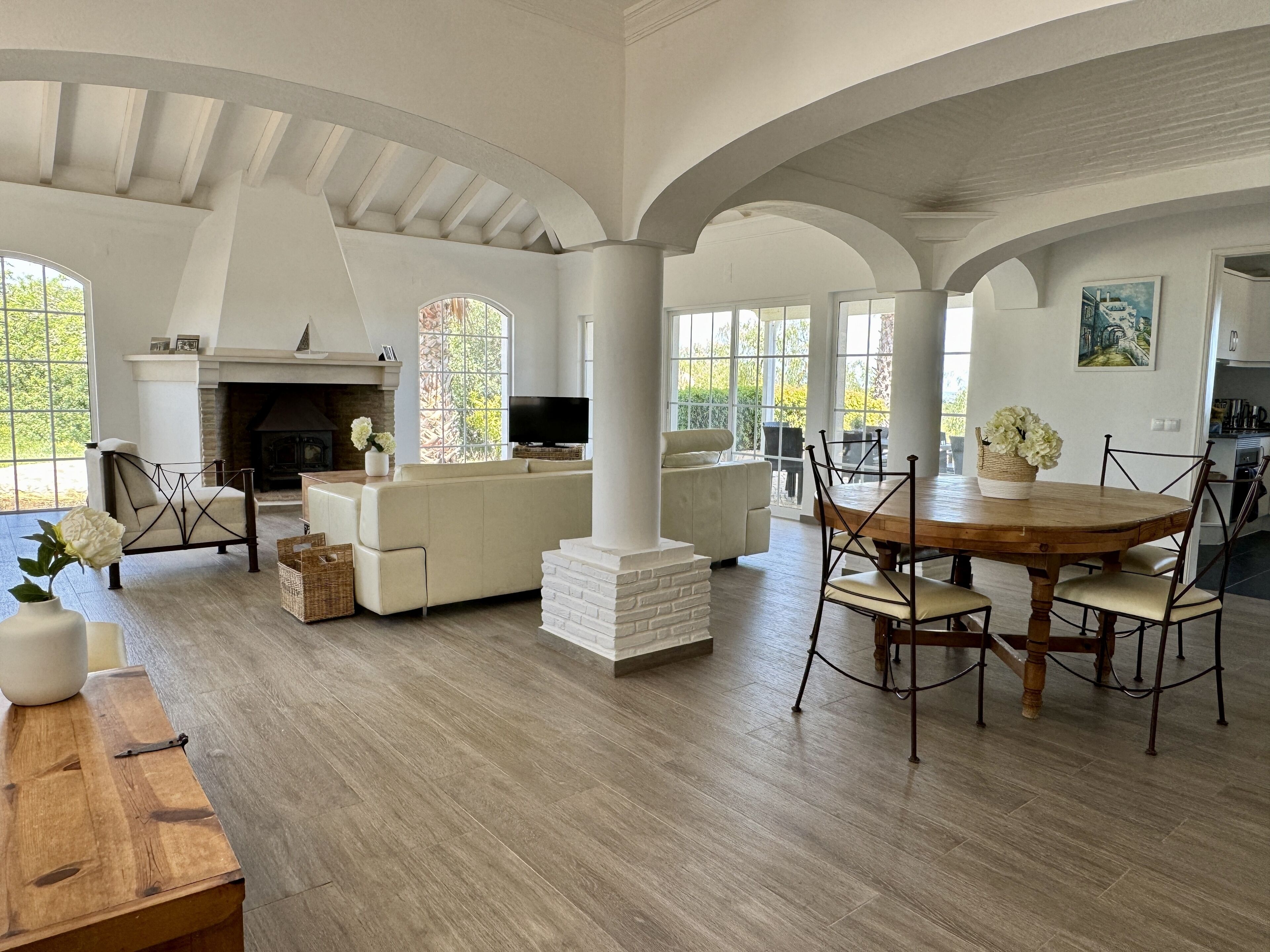 A spacious living area with a fireplace, comfortable seating, and a dining table.