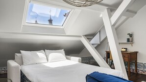 A bedroom with a skylight, a bed, a bedside table, and a chair. - New! Everything BRAND new 23-  Luxury Prime Location Great for Family & Friends (Lisboa)