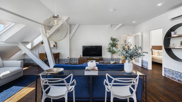 A modern living room with a central island, white sofas, a TV, and a dining area with chairs. - New! Everything BRAND new 23-  Luxury Prime Location Great for Family & Friends (Lisboa)