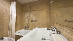 Un baño con dos lavamanos, una ducha y un bidé.