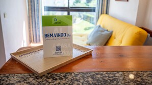 Un folleto titulado 'BEM.VINDU (A)' sobre una bandeja de madera.