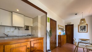 Una cocina con armarios de madera, un fregadero y una barra con taburetes.