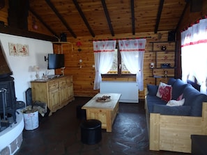 A cozy cabin interior with a stone floor, wooden furniture, a fireplace, and a television. - Chalet near La Bresse-Gérardmer, WIFI (Basse-Sur-Le-Rupt)