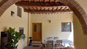 A cozy room with a wooden door, a table with chairs, and a large potted plant. - Three-room apartment, 80 square meters, 5/7 persons with swimming pool, 8 km from the center of Florence (Scandicci, Firenze)