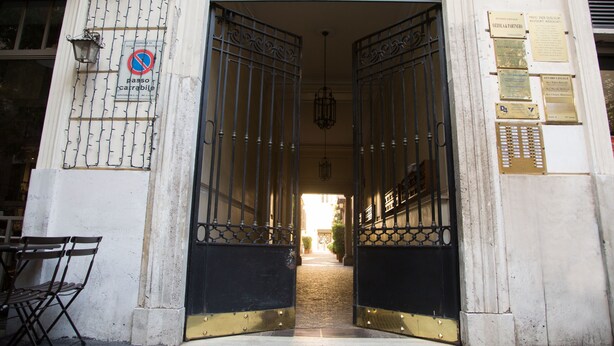 A building entrance with barred gates, a no parking sign, and several plaques on the wall. - Rome Boutique Apartments, central, delightful, close to the center and the vatican (6900333)
