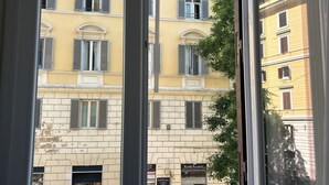 A window with a view of a building with multiple windows and balconies. - Rome Boutique Apartments, central, delightful, close to the center and the vatican (6900333)