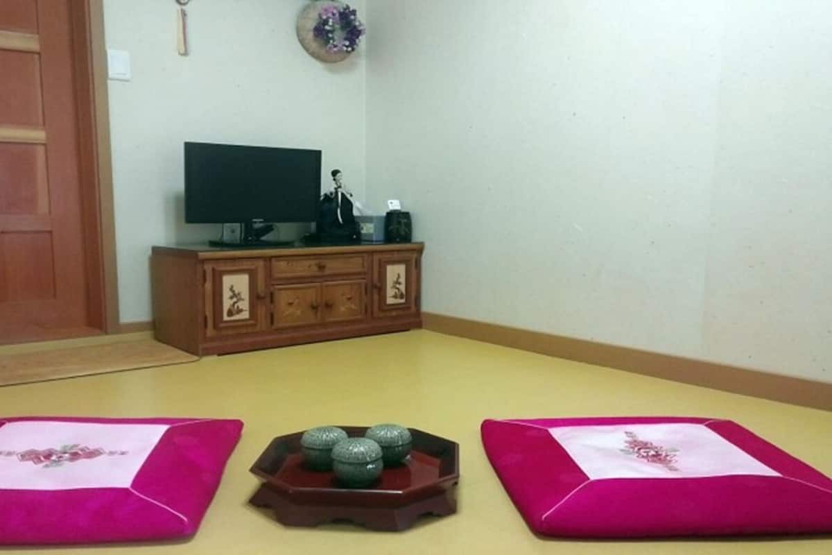 A room with a wooden cabinet, a television, and a decorative item on the wall.