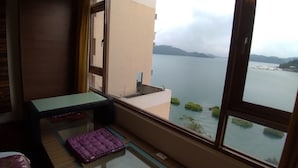 A balcony with a view of a body of water and distant hills. - Miracolo View Hotel (Yuchi)