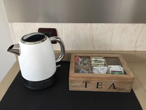 A white electric kettle and a wooden box labeled 'TEA' with tea packets on a black mat. - NEXT TO LAS CANTERAS BEACH! Lovely and spacious apt. 80 m2 well located (Las Palmas de Gran Canaria)