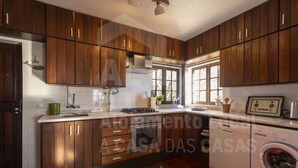 Une cuisine moderne avec des meubles en bois, une cuisinière encastrée et un lave-linge.