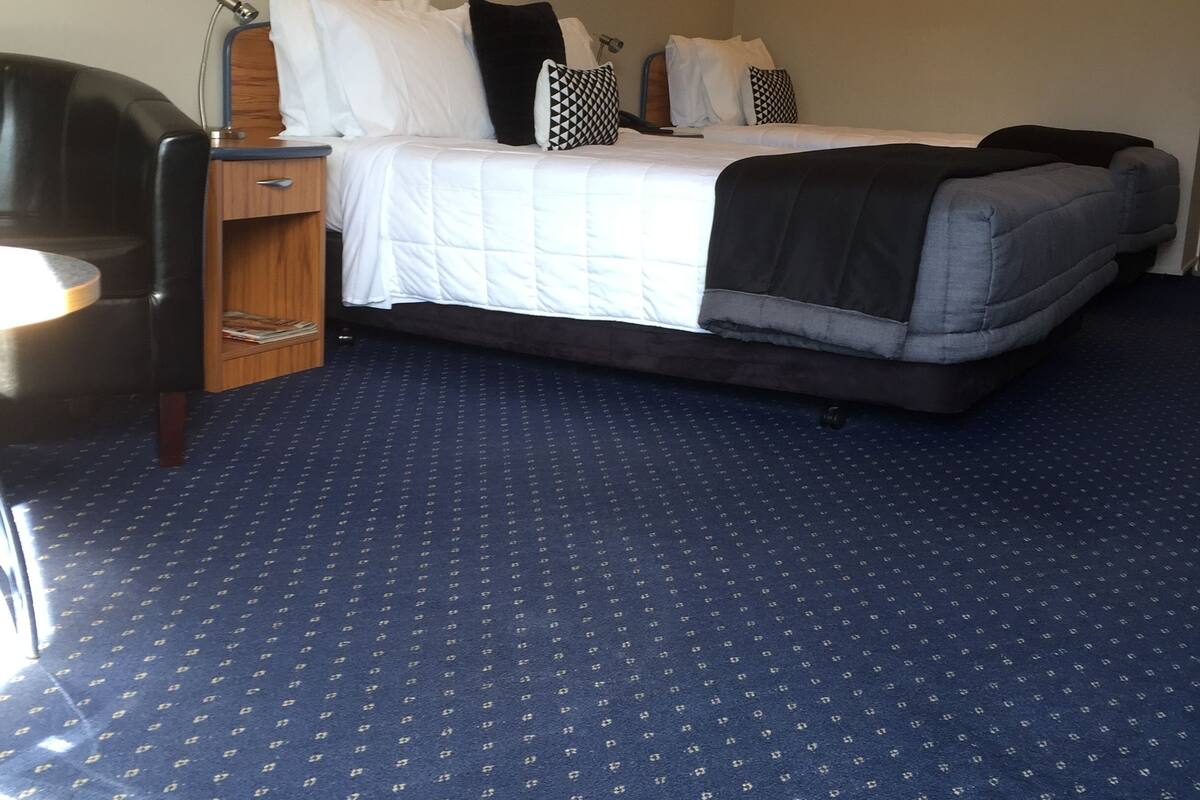 A hotel room with a bed, a desk, and a chair.