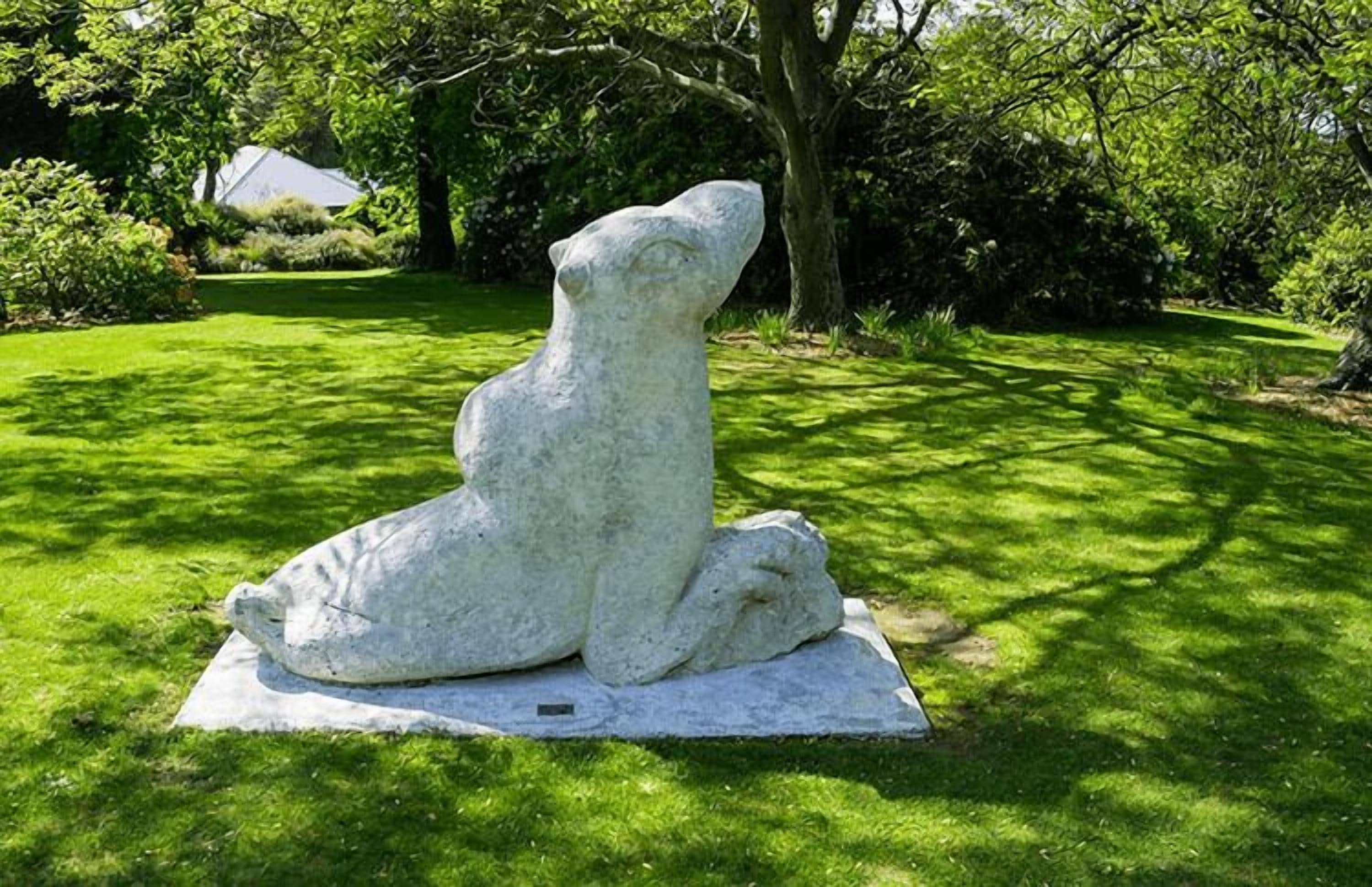 Una escultura de piedra de un oso en un parque.