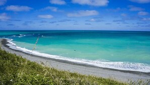 Une plage avec une eau turquoise cristalline et un rivage sablonneux.