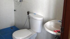 A bathroom with a toilet, a sink, and a shower. - All Day Hotel (Nong Khai)