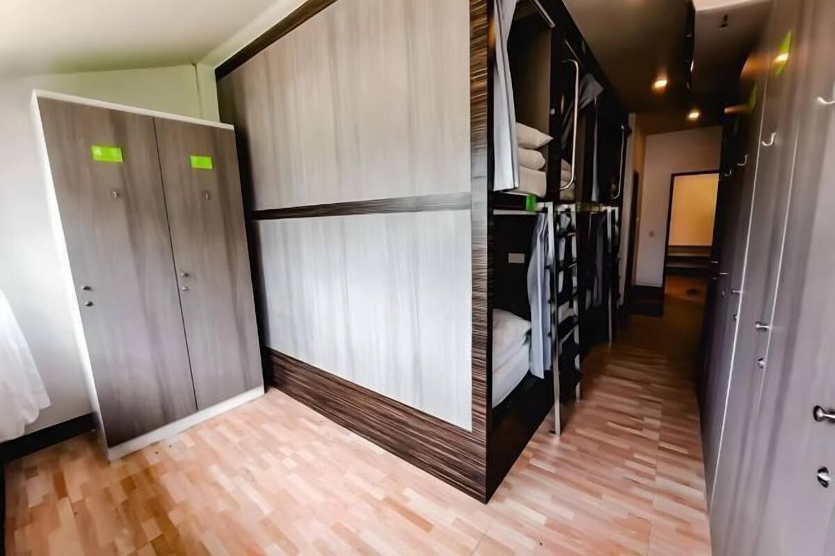 Ein Hotelzimmer mit Schrank, Bett und einem Flur, der zu einer Treppe führt.