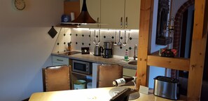 Een koffiezetapparaat/waterkoker, kookgerei, borden en bestek