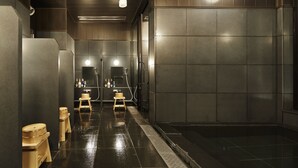 A modern bathroom with a wet floor, wooden stools, and a large mirror. - the square hotel GINZA (Tokyo)