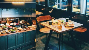 A restaurant with a bar, wooden tables, and a view through large windows. - the square hotel GINZA (Tokyo)