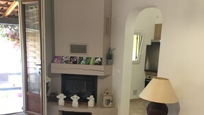 A living room with a fireplace, a sofa, a small table, and a lamp. - rent large calm F1 at the door of the center town of Ajaccio (Sarrola-Carcopino)