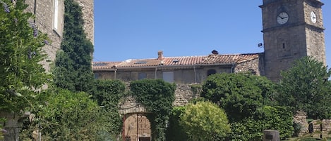 A stone pathway leading to a historic building with a clock tower.