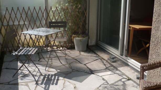 A patio with stone flooring, a table, chairs, and a potted plant. - STUDIO IN A SEA FACING RESIDENCE WITH GARDEN VIEW (Boulogne-sur-Mer)
