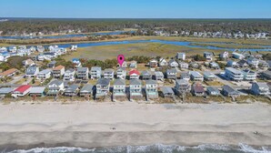 A coastal residential area with beachfront properties, a beach, and a water body in the background. - Don't Worry Beach Happy: Ocean View, Swimming Pool (Oak Island)