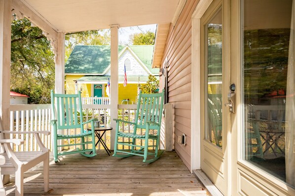 Relax on the covered porch with two comfortable chairs and a small table.