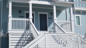 Ein zweistöckiges Haus mit Veranda und Treppe.