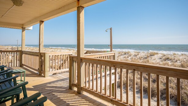 A wooden deck with benches overlooking a beach with sand dunes and the ocean. - Dip Inn: Basic beach house with upgraded appliances (Oak Island)