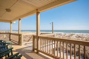 A wooden deck with benches overlooking a beach with sand dunes and the ocean. - Dip Inn: Basic beach house with upgraded appliances (Oak Island)