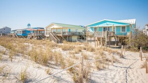 A beachfront property with multiple wooden structures, including a main building and several smaller cabins, connected by wooden walkways. - Dip Inn: Basic beach house with upgraded appliances (Oak Island)