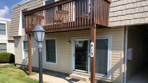 A two-story apartment building with a wooden balcony, a visible number '415' on the door, and a street lamp in the foreground. - Beautiful 2-BR Bayside Condo W/Pool, Gull Way Villas, Short Walk To Beach (Ocean City)