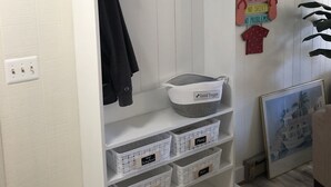 A white storage unit with a 'BEACH' sign, hooks, and labeled baskets. - Beautiful 2-BR Bayside Condo W/Pool, Gull Way Villas, Short Walk To Beach (Ocean City)
