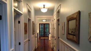 A hallway with wooden flooring, white wainscoting, and multiple doors. - NEW FALL RATES! Picturesque Cottage Retreat in Cassine Village, Seagrove Beach (Santa Rosa Beach)