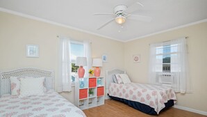 A bedroom with two beds, a ceiling fan, and a white wardrobe with drawers. - The Hideaway: Dog-friendly Unit in Multiplex Close to Public Beach Access (Oak Island)