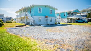 A two-story building with a blue exterior and a white balcony. - The Hideaway: Dog-friendly Unit in Multiplex Close to Public Beach Access (Oak Island)