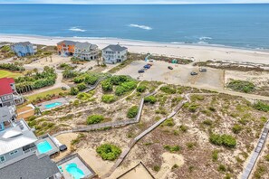 A coastal property with multiple buildings, a beach, and a parking area.