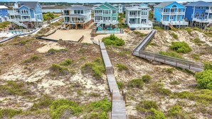 Una zona costera con casas de playa conectadas por una pasarela de madera.