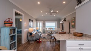 A spacious kitchen with a dining area, wooden cabinets, and a ceiling fan.