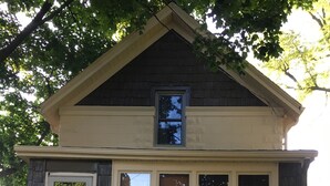A small, single-story house with a front door, a small porch, and a mailbox.