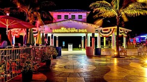 Entrada de un hotel con un cartel luminoso que dice LAUDERDALE-BY-THE-E-SEA.