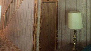 Una scala in legno con corrimano che porta a una porta.