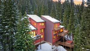 A multi-story lodge with a red exterior, surrounded by snow-covered trees. - Blue Bend Beauty | Comfort & Privacy with Postcard Views & Private Hot Tub (Breckenridge)