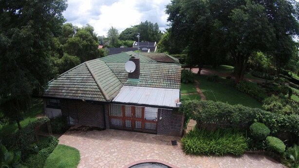 A house with a swimming pool, surrounded by a garden and trees. - Cana Guest House (Harare)