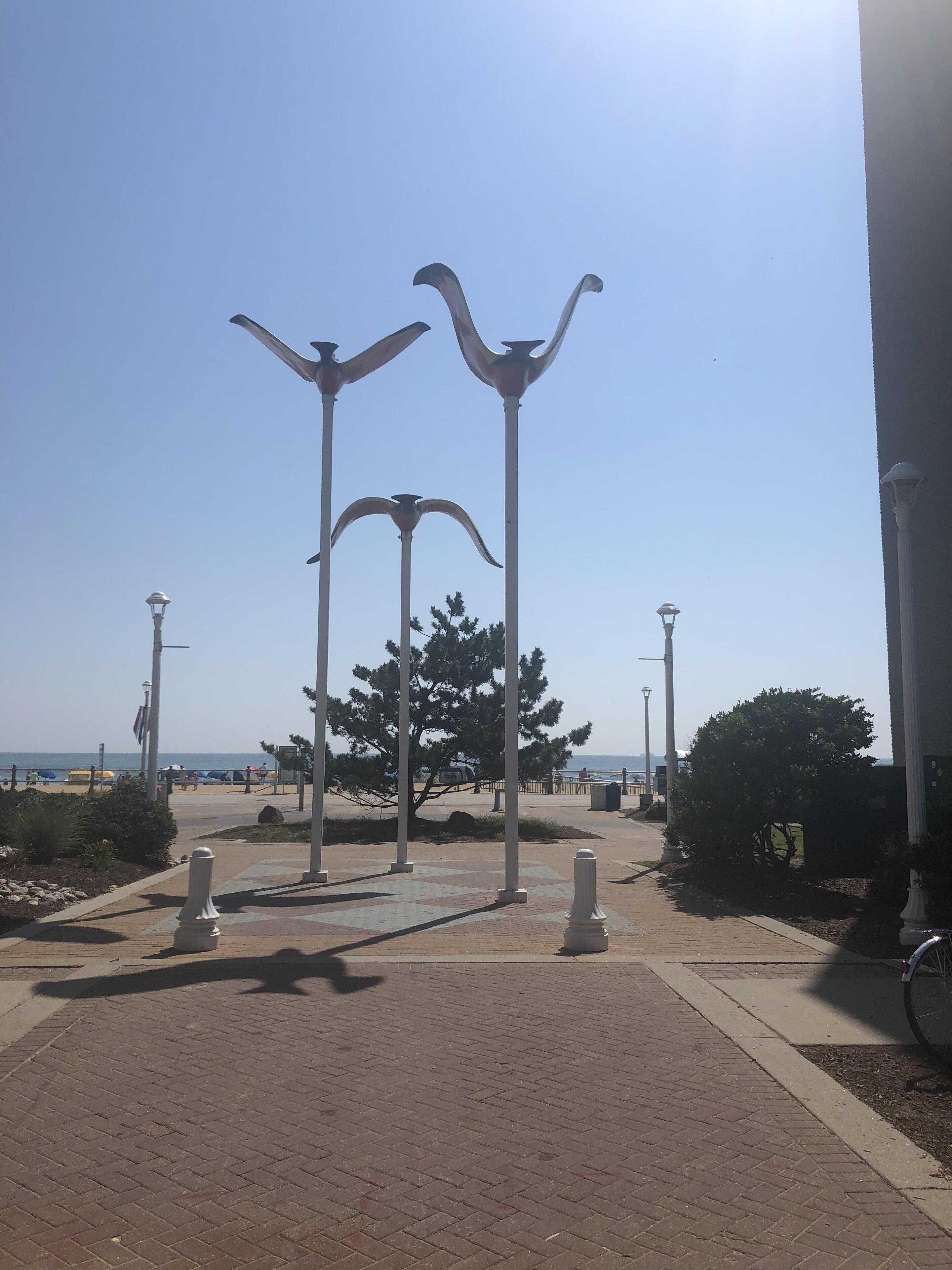 A paved walkway with street lamps and decorative bollards.