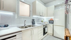 A modern kitchen with white cabinetry, a built-in oven, and a microwave.