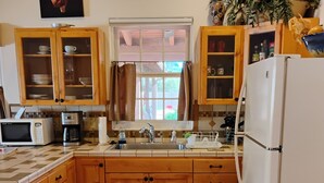 A kitchen with wooden cabinets, a white refrigerator, a microwave, and a coffee maker. - 1/2 mile from large bike/walk path  and 3 miles from the U of A (Tucson)