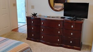A bedroom with a bed, a dresser, a television, and a door leading to a balcony. - 1/2 mile from large bike/walk path  and 3 miles from the U of A (Tucson)
