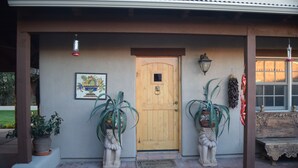 A wooden door with a small window, a welcome mat, and two potted plants with decorative pots. - 1/2 mile from large bike/walk path  and 3 miles from the U of A (Tucson)