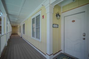 A corridor with a wooden floor, white doors, and a sign that reads 'Make a wish upon a Starfish.' - Star Fish: Ocean View Condo with Pool and Hot Tub (Oak Island)